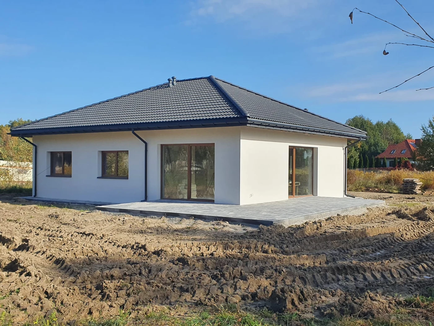 Dom parterowy z jasną elewacją i szerokim przeszkleniem